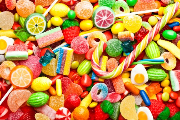 Top view of colorful candies, jellybeans and lollipops background. DSRL studio photo taken with Canon EOS 5D Mk II and Canon EF 100mm f/2.8L Macro IS USM